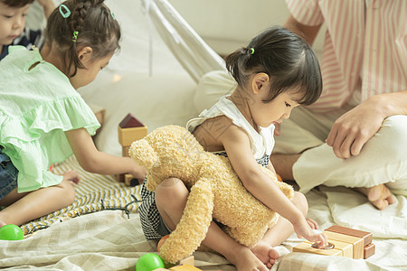 抱着玩具熊玩耍的小女孩儿童保育高清图片素材