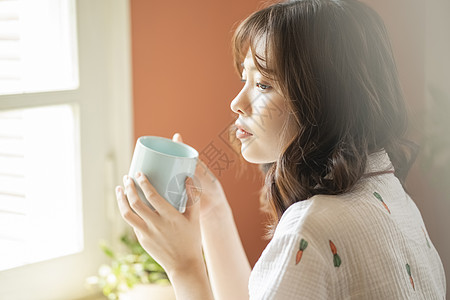 暖茶拿着咖啡的年轻女子背景