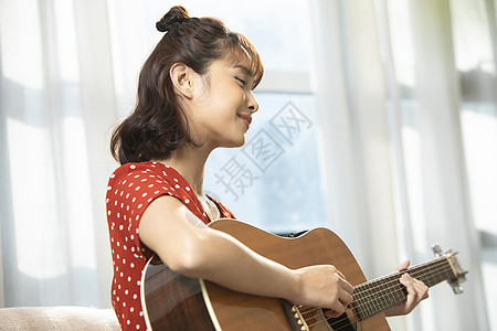 弹吉他的居家女孩图片