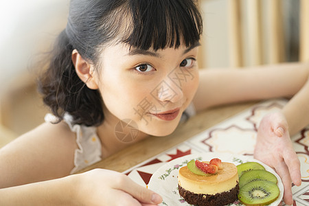 下午茶吃蛋糕的年轻女子图片