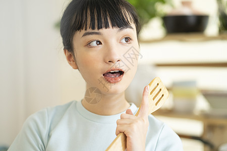 年轻妈妈居家烹饪美食的可爱女孩背景