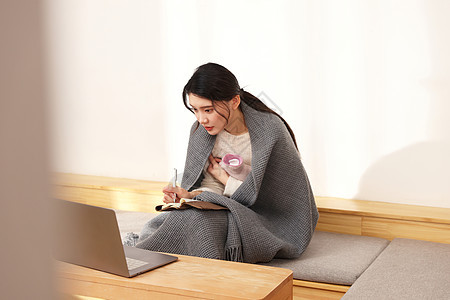 居家办公裹着毛毯的女性图片