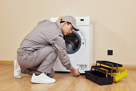 维修工人检修滚筒洗衣机高清图片