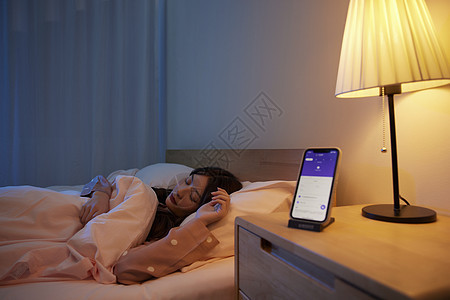 夜晚手机监测年轻女性的睡眠状况世界睡眠日高清图片素材