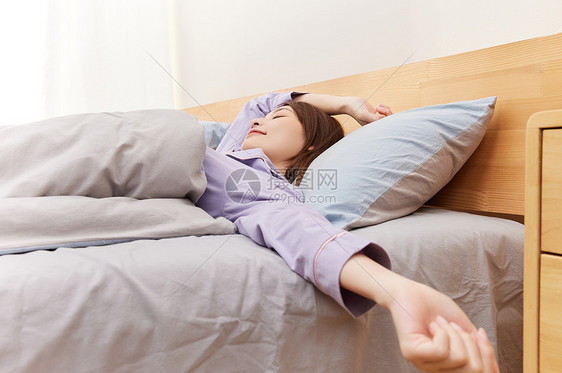 睡醒的年轻女性伸懒腰图片