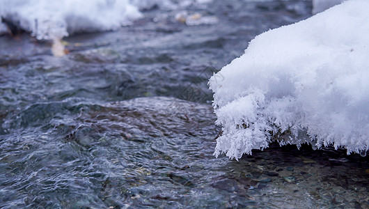 溪流边正在融化的积雪图片