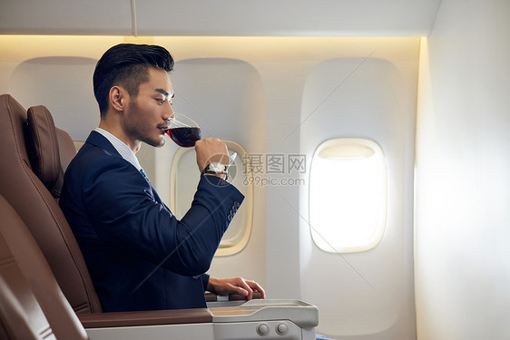 商务男士飞机商务舱喝红酒图片