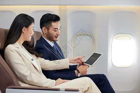 商务男女在飞机上讨论工作图片