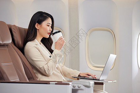 在飞机上喝咖啡的职场女性图片