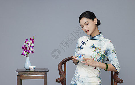 年轻旗袍女性端坐品茶背景图片