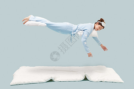 穿着睡衣的年轻少女悬浮在空中高清图片