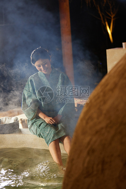 穿着日式浴衣的女性坐在温泉里泡脚图片