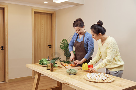 家人一起做饭女儿和妈妈在厨房一起包饺子背景