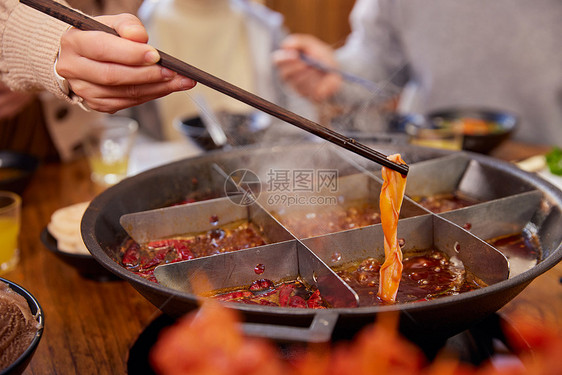 火锅店吃火锅夹菜特写图片