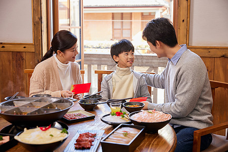 火锅店吃火锅发红包的新年家庭图片