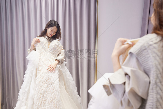 女性抱着婚纱放在身上比较图片