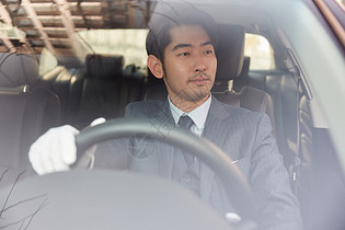 男性专车司机手握方向盘驾驶汽车图片