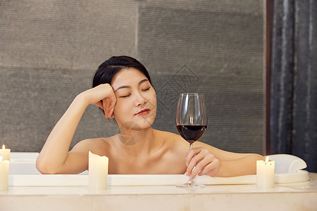 美女浴缸泡澡喝红酒背景图片