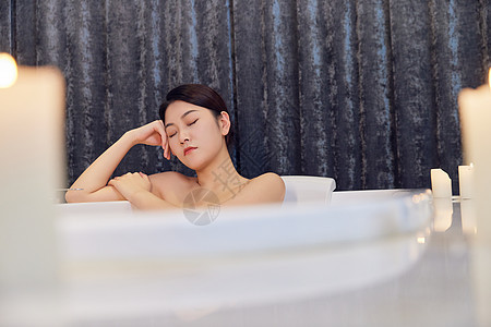 青年女性浴缸泡闭眼休息背景图片