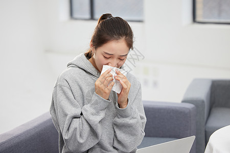 室内雾霾室内过敏的女性使用纸巾擦鼻子背景