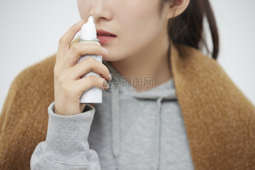 居家鼻炎的女性使用鼻炎喷雾治疗图片