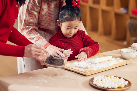 奶奶和妈妈指导小女孩包汤圆高清图片