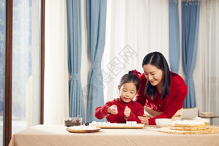 家人团聚元宵节妈妈陪着女儿包汤圆背景