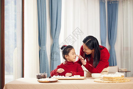 端着汤圆的妈妈元宵节妈妈陪着女儿包汤圆背景