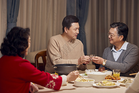 春节年夜饭父子喝白酒碰杯背景图片