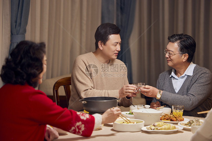 春节年夜饭父子喝白酒碰杯图片