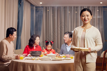 端着汤圆的妈妈年轻妈妈元宵节聚餐端着汤圆形象背景