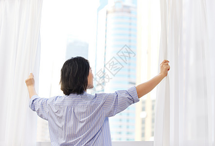 居家中年女性早晨拉开窗帘背影图片