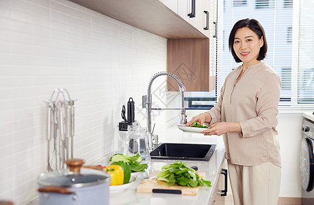 气质中年女性在家厨房切菜图片
