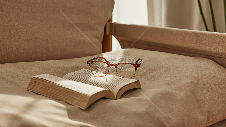 午后阳光沙发上的书籍和眼镜图片