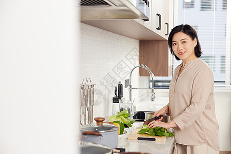 中年女性在厨房切菜形象图片