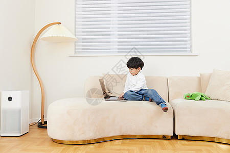 儿子小男孩在沙发上玩耍看电脑背景