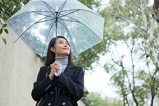 下雨天撑伞的年轻女性图片