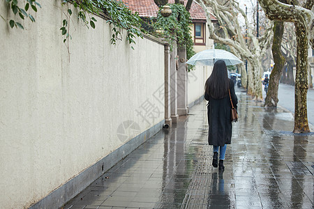 下雨天撑伞的女性背影图片