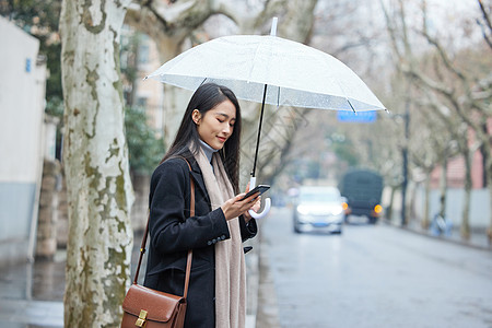 雨天撑着伞在路边等待的女性背景图片