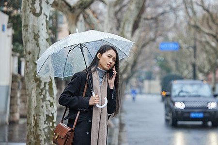 雨伞美女下雨天在路边着急等车的女性背景