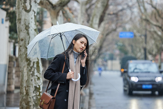 下雨天在路边着急等车的女性图片