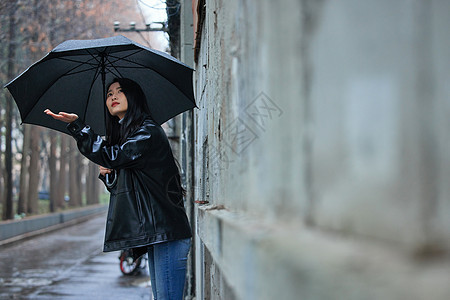 屋檐下等雨停的女性图片