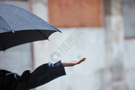 下雨天撑伞的女性手部特写背景图片