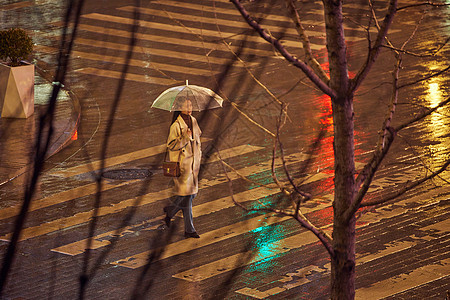 夜晚雨天过斑马线的女人背景图片