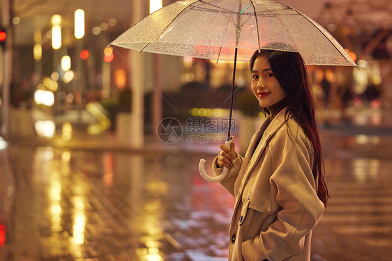 下雨天夜晚城市里散步的女性图片