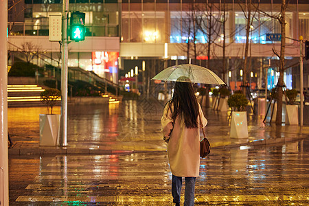 夜晚走路下雨天过马路的女性背影背景