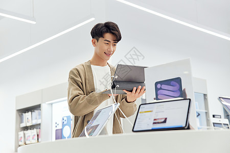 数码店体验平板电脑的青年男性图片