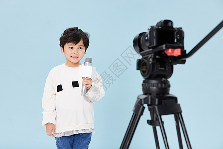 手拿话筒录制节目的小男孩图片