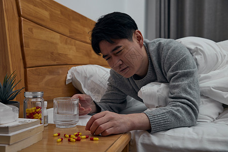 患病中年男性卧床吃药图片