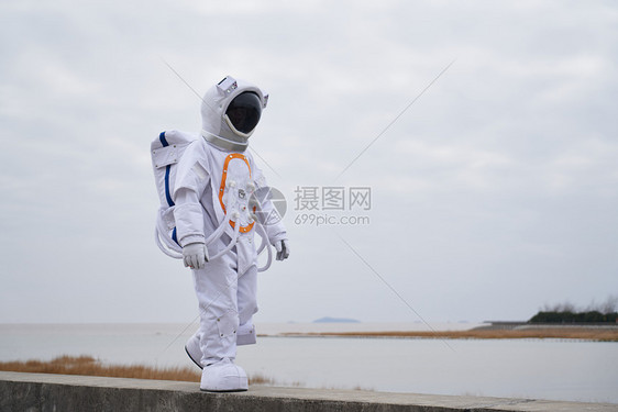 穿着宇航服的男性海边行走图片